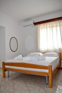 a bedroom with a wooden bed with a window at Ksamil Sea&Lake view Escape in Ksamil