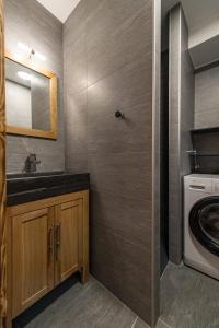 a bathroom with a sink and a washing machine at Appartement neuf avec terrasse plein sud - 6 personnes in Saint-Sorlin-dʼArves