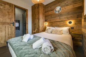 a bedroom with a bed with towels on it at Appartement neuf avec terrasse plein sud - 6 personnes in Saint-Sorlin-dʼArves