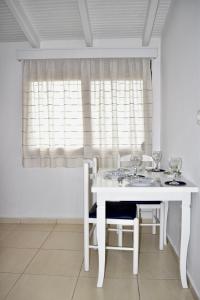 a white dining room table with two chairs and a window at Ksamil Sea&Lake view Escape in Ksamil
