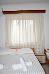 1 dormitorio con 2 camas blancas y ventana en Ksamil Sea&Lake view Escape, en Ksamil