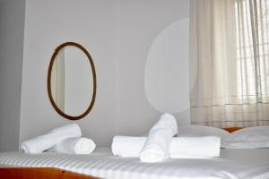 a room with a bed with a mirror and towels at Ksamil Sea&Lake view Escape in Ksamil