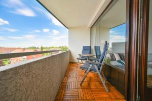 un balcone con sedie, una scrivania e una vista di Ferienwohnung Hygge Sol Mare Whg 52 mit Schwimmbad Innenpool und Sauna Kellenhusen a Kellenhusen Altre 12 foto