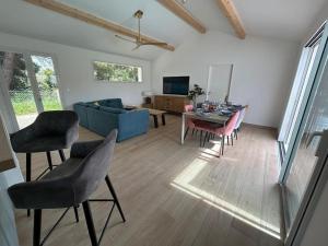 een woonkamer met een blauwe bank en een tafel bij Villa Les Sables Vigniers, Piscine et Jacuzzi prives, plage à 800m in Les Sables Vignier