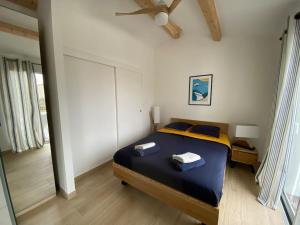 een slaapkamer met een bed met twee handdoeken erop bij Villa Les Sables Vigniers, Piscine et Jacuzzi prives, plage à 800m in Les Sables Vignier