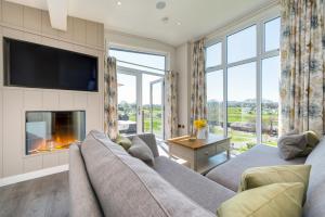 a living room with a couch and a fireplace at Cofton Holidays in Dawlish