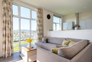 a living room with a couch and large windows at Cofton Holidays in Dawlish