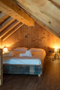 um quarto com uma cama num sótão de madeira em Chalet de charme 11 personnes proche du centre du village em Saint-Sorlin-dʼArves