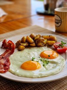 um prato com dois ovos, bacon e batatas em Coffee Estate Inn em Boquete