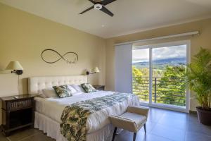 ein Schlafzimmer mit einem Bett und einem großen Fenster in der Unterkunft Coffee Estate Inn in Boquete