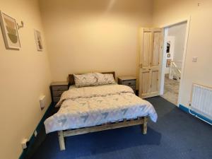 Habitación pequeña con cama y puerta en Pink door house in Clifden, en Clifden