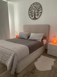 a bedroom with a bed with a tree on the wall at Alecu Home in Puerto del Carmen