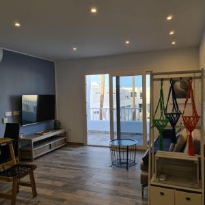 a living room with a tv and a couch and a table at Alecu Home in Puerto del Carmen