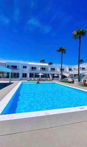 a large swimming pool in front of a building at Alecu Home in Puerto del Carmen