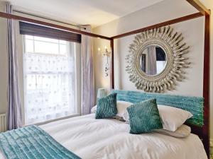 1 dormitorio con 1 cama con espejo en la pared en Sunbeams, en Chichester