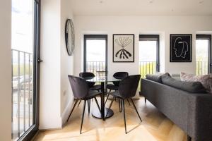 a living room with a table and chairs and a couch at Staines Riverside by Charles Hope in Staines