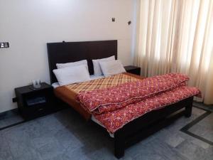 a bedroom with a large bed with avertisement at Kashmir Inn Hotel in Muzaffarabad