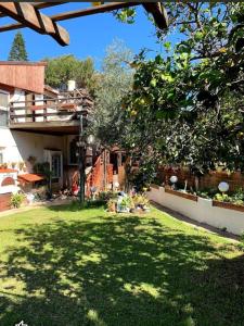 een tuin van een huis met een boom en gras bij Czarina Cabin הבקתה הקיסרית in Caesarea