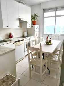 a white kitchen with a white table and chairs at 4 bedrooms house with city view and terrace at Burgos in Burgos