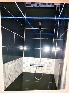 a shower in a bathroom with black and white tiles at 4 bedrooms house with city view and terrace at Burgos in Burgos