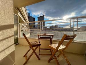 einen Balkon mit 2 Stühlen und einem Tisch auf dem Balkon in der Unterkunft Skyview appartement la Défense in Courbevoie