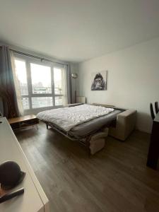 een slaapkamer met een bed en een groot raam bij Skyview appartement la Défense in Courbevoie