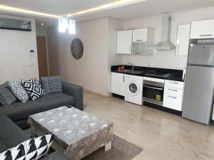 sala de estar con sofá y cocina en Appartement au Parc Mohammedia, en Mohammedia