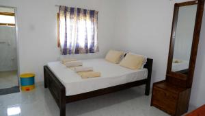 Bett in einem Zimmer mit Spiegel in der Unterkunft Attale Resort in Hambantota