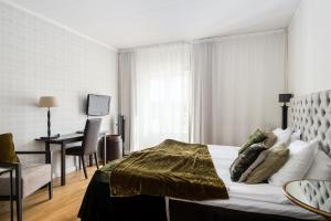 um quarto com uma cama e uma secretária num quarto em Körunda Golf & Conference Hotel em Ösmo