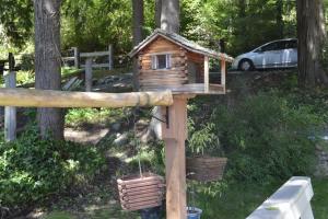 una casa de pájaros de madera con dos macetas. en Guppies Lakehouse-Prvt. Lake Acc, Close to Rainier, en Graham