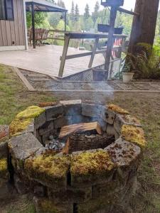 una hoguera de piedra en un patio con una mesa de picnic en Guppies Lakehouse-Prvt. Lake Acc, Close to Rainier, en Graham