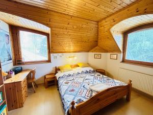 um quarto com uma cama e um tecto de madeira em Nefelejts Deluxe Home em Zamárdi