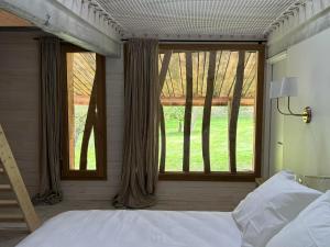a bedroom with a bed and a large window at La Marbecque in Samer