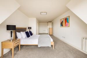 um quarto com uma grande cama branca e uma mesa em Staines City Centre by Charles Hope em Staines