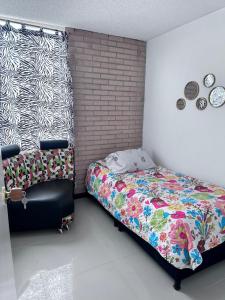 a bedroom with a bed and a chair in it at Apto en Palmira valle in Palmira