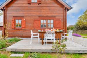 a table and chairs on a deck in front of a cabin at Paisible et insolite chalet pour 4 personnes a Penmarch in Penmarcʼh +10 photos