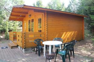 a small wooden cabin with a table and chairs at Domki nad jeziorem Mrągowo-Marcinkowo in Mrągowo +9 photos
