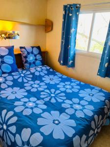 a bedroom with a blue bed with blue flowers at Bungalow bleu in Roquebrune-sur-Argens