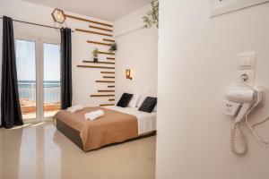 a bedroom with a bed and a phone on the wall at C'est La Vie Rooms and Suites in Laganas