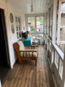 eine Veranda mit einer Bank, einem Tisch und Fenstern in der Unterkunft La Casina de Paula 2 in Ríoseco