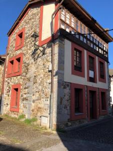 ein altes Backsteingebäude mit roten Rollläden darauf in der Unterkunft La Casina de Paula 2 in Ríoseco
