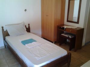 Dormitorio con cama con espejo y tocador en LYGIROS ANASTASIOS, en Tarti