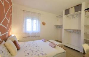 - une chambre avec un lit doté d'oreillers roses et d'une fenêtre dans l'établissement Apartment Otto, à Novigrad