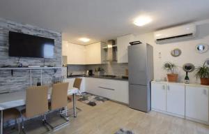 une cuisine avec des placards blancs et une table avec des chaises dans l'établissement Apartment Otto, à Novigrad