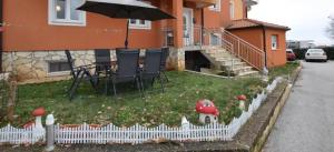 une maison avec une table, des chaises et un parasol dans l'établissement Apartment Otto, à Novigrad