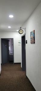un pasillo con dos puertas y un reloj en la pared en Duisburger Hostel, en Duisburg