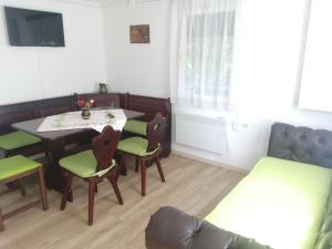 een woonkamer met een tafel en stoelen en een bank bij Ikerdió faházikó in Szarvas