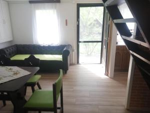 a living room with a couch and a table at Ikerdió faházikó in Szarvas