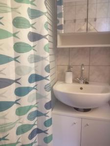 a bathroom with a sink and a shower curtain at Ikerdió faházikó in Szarvas +12 photos