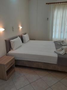 a large bed with white sheets and pillows in a room at Barbara II in Agia Marina Aegina